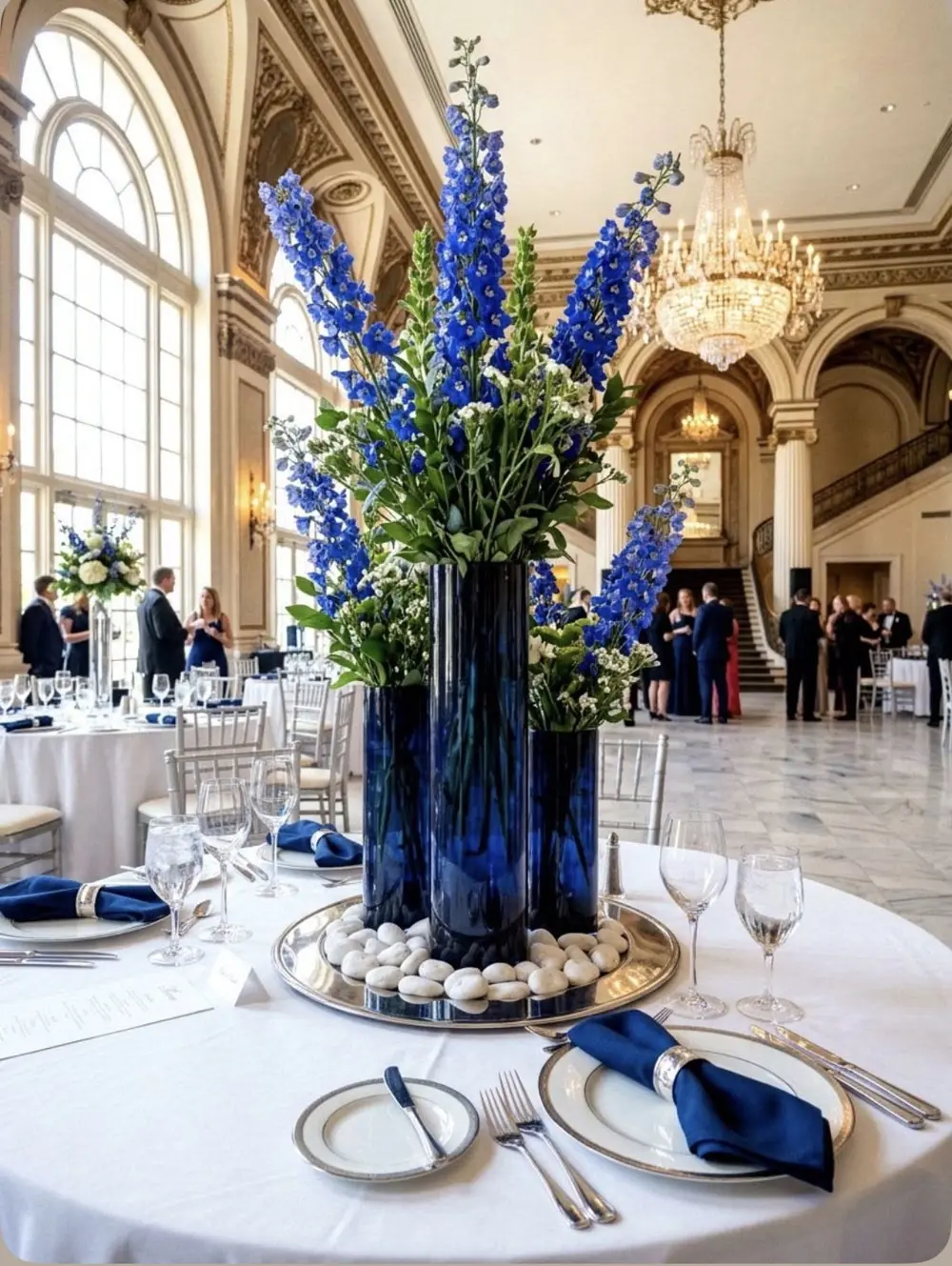Tall blue delphinium floral arrangement in an elegant ballroom